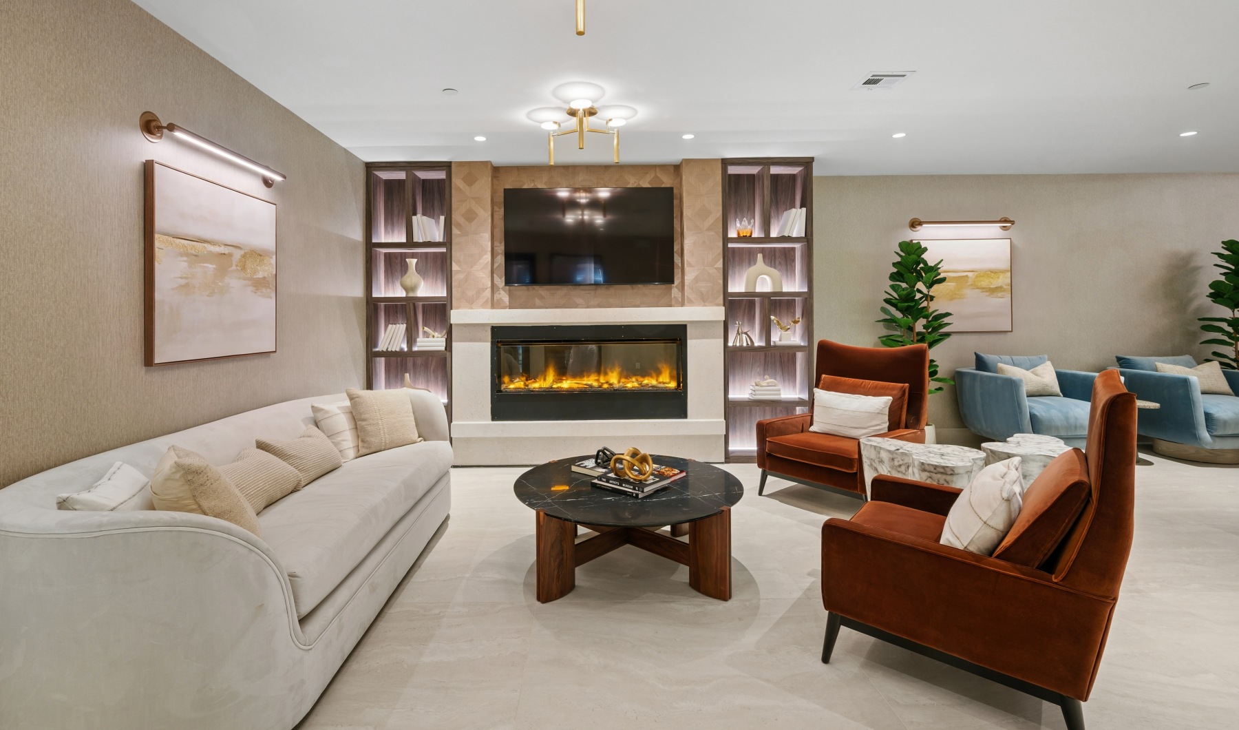 Clubroom with sofa and chairs with an electric fireplace.
