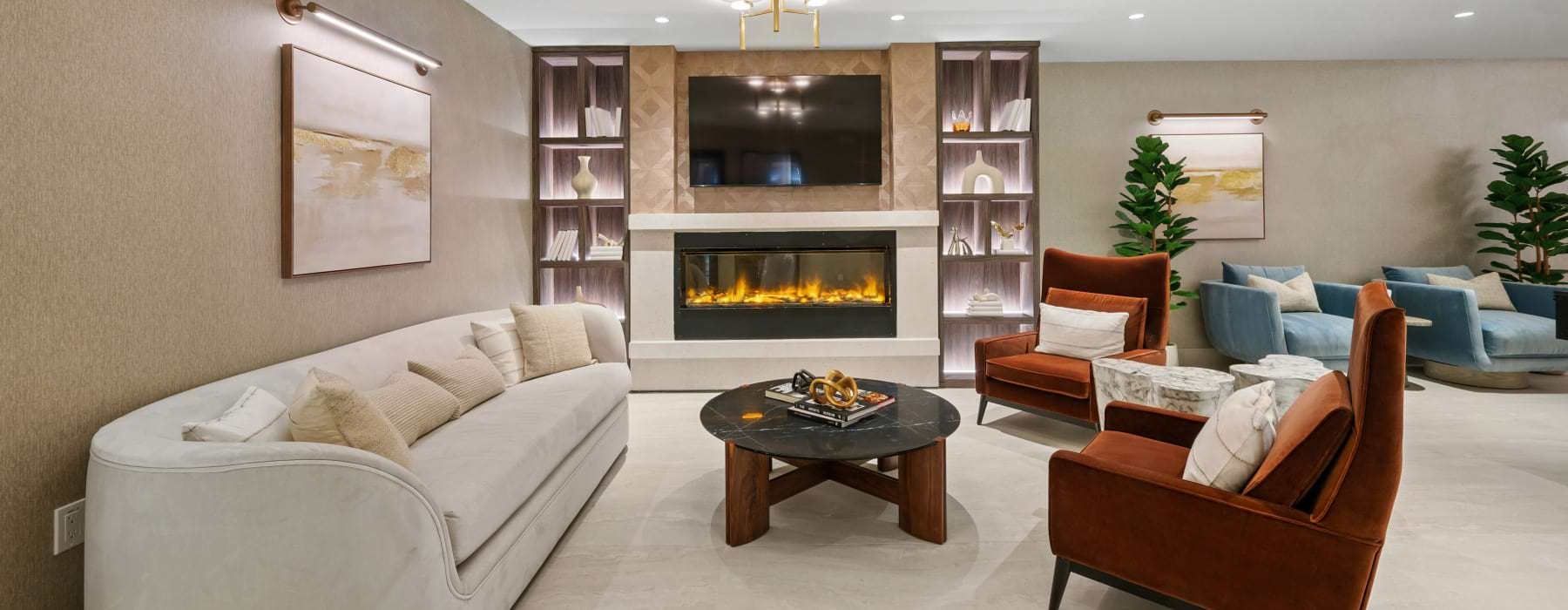 Clubroom with couch, chairs, and electric fireplace.