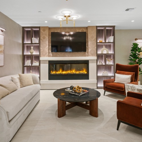 Clubroom with couch, chairs, and electric fireplace.